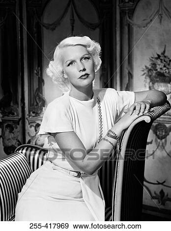Mid adult woman sitting in elegant chair View Large Photo Image Stock Photo - Mid adult woman sitting in elegant chair. Fotosearch