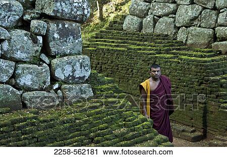 Stock Image - Monk at the ruins of a fort, Sigiriya, Matale District, Sri Lanka. Fotosearch