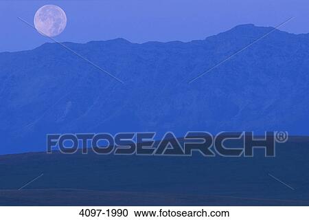 Stock Image - Moon over mountain, Alberta, Canada. Fotosearch