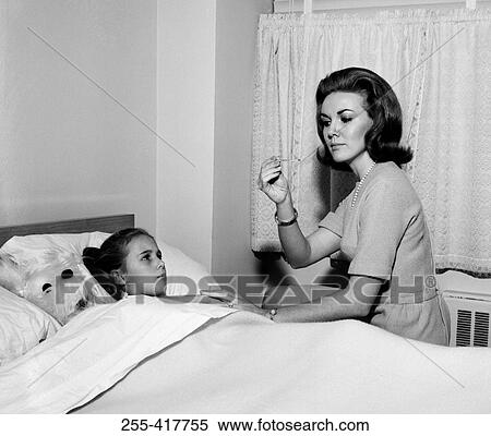 Mother checking daughter's temperature in bed View Large Photo Image Stock Photography - Mother checking daughter's temperature in bed. Fotosearch