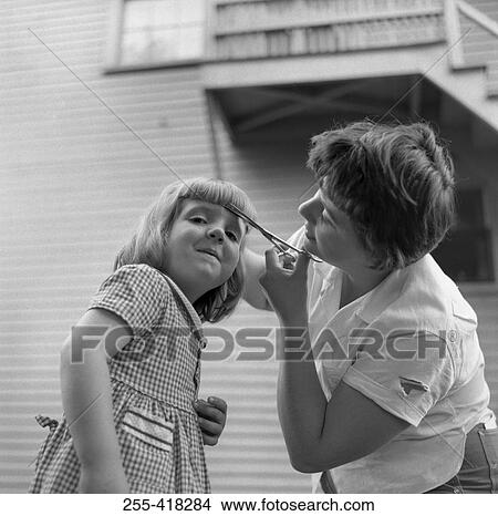 Mother cutting daughter's fringe View Large Photo Image Picture - Mother cutting daughter's fringe. Fotosearch