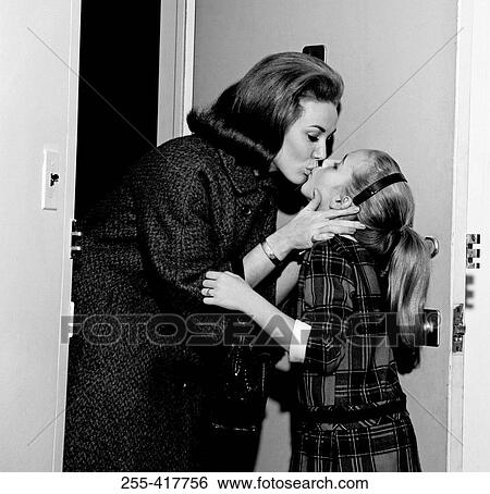 Stock Photograph - Mother kissing daughter goodbye. Fotosearch