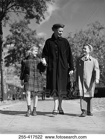 Stock Image - Mother with kids walking through park. Fotosearch
