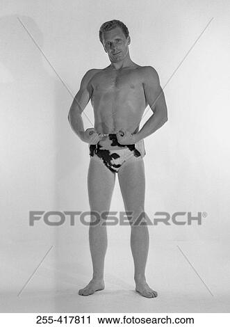 Stock Image - Muscular man wearing animal print trunks, studio shot. Fotosearch