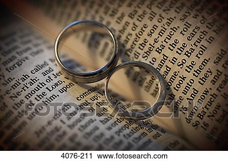 Pair of wedding rings on an open Bible View Large Photo Image Stock Image - Pair of wedding rings on an open Bible. Fotosearch