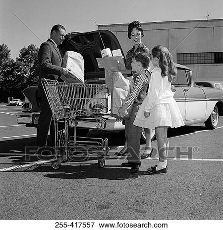 Parents and kids loading shopping bags into car trunk View Large Photo Image Stock Photo - Parents and kids loading shopping bags into car trunk. Fotosearch