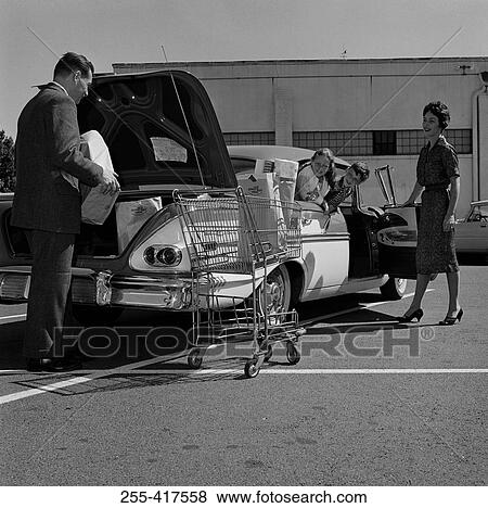 Parents and kids loading shopping bags into car trunk View Large Photo Image Stock Photo - Parents and kids loading shopping bags into car trunk. Fotosearch