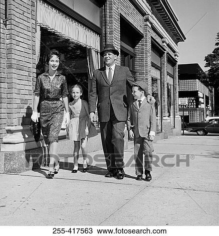 Stock Image - Parents and kids walking down street. Fotosearch
