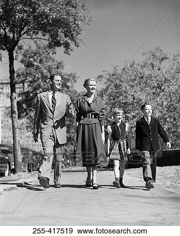 Stock Photo - Parents with kids walking through park. Fotosearch