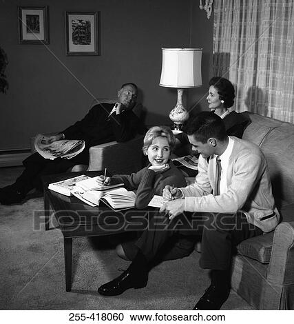 Stock Image - People relaxing in living room. Fotosearch