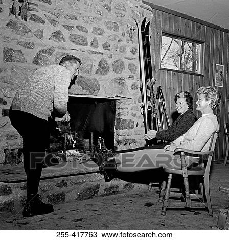 Stock Image - People sitting near fireplace. Fotosearch