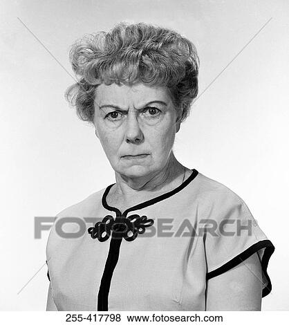 Stock Photo - Portrait of displeased mature woman frowning forehead, studio shot. Fotosearch