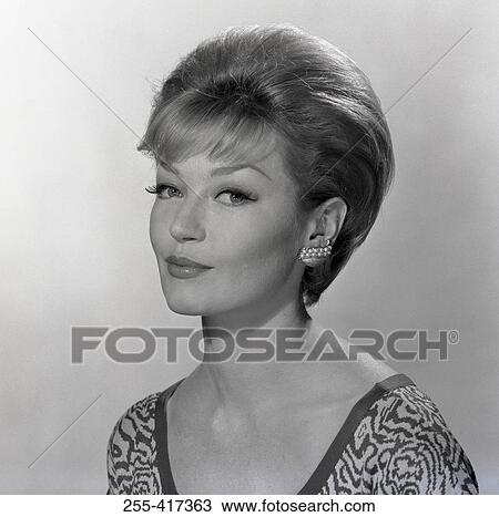Stock Image - Portrait of elegant smiling woman, studio shot. Fotosearch
