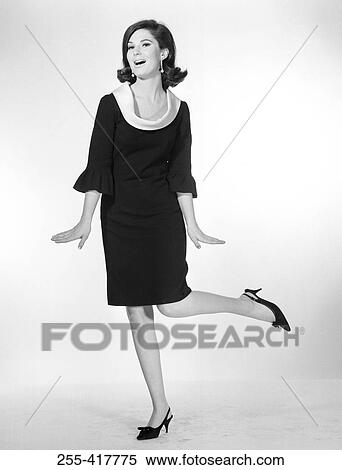Portrait of elegant woman wearing dress and standing in one leg, studio shot View Large Photo Image Stock Photography - Portrait of elegant woman wearing dress and standing in one leg, studio shot. Fotosearch