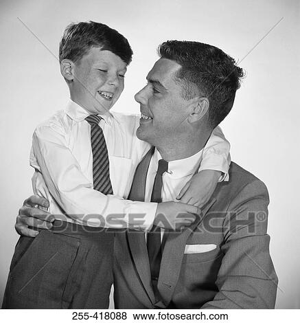 Stock Photo - Portrait of father and son embracing. Fotosearch