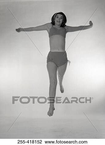 Stock Image - Portrait of jumping woman in bikini. Fotosearch