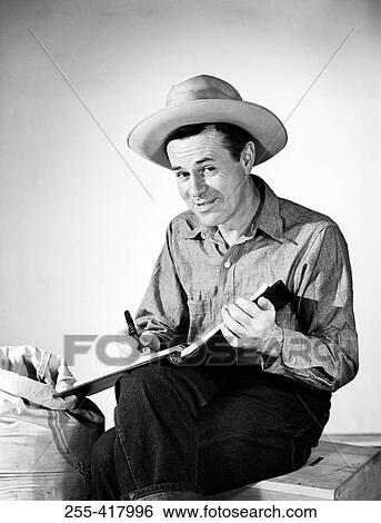 Portrait of mature cowboy writing in book View Large Photo Image Stock Photograph - Portrait of mature cowboy writing in book. Fotosearch