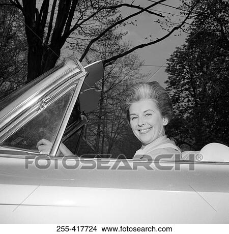 Portrait of mature woman sitting in car View Large Photo Image Picture - Portrait of mature woman sitting in car. Fotosearch