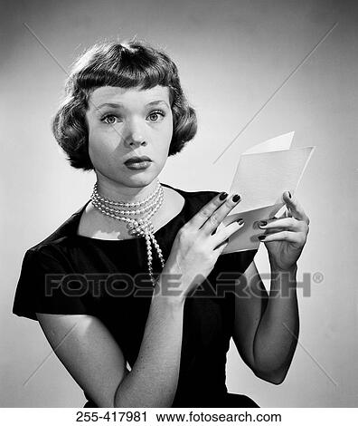 Stock Image - Portrait of young woman holding letter. Fotosearch