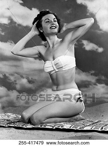 Portrait of young woman sitting on beach View Large Photo Image Stock Photo - Portrait of young woman sitting on beach. Fotosearch