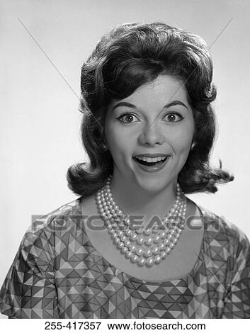 Stock Photo - Portrait of young woman smiling, studio shot. Fotosearch