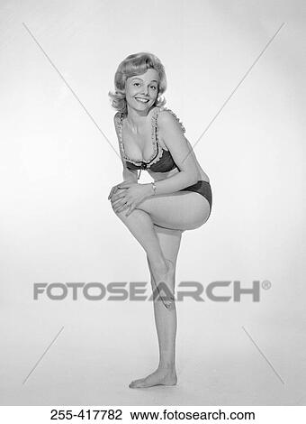 Portrait of young woman standing on one leg in underwear, studio shot View Large Photo Image Stock Image - Portrait of young woman standing on one leg in underwear, studio shot. Fotosearch
