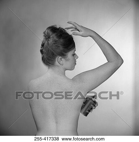 Rear view of young woman using deodorant View Large Photo Image Stock Photo - Rear view of young woman using deodorant. Fotosearch
