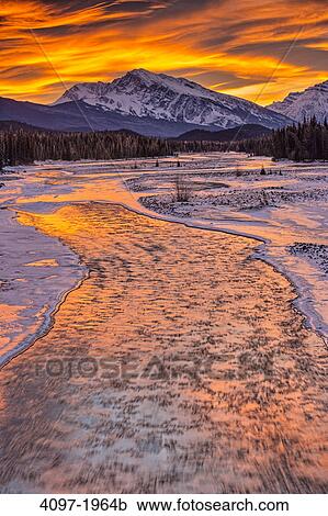Stock Image - River flowing with a mountain in the background, Athabasca River, Mt Kerkeslin, Jasper National Park, Alberta, Canada. Fotosearch