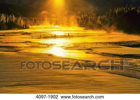Stock Image - River passing through a forest at sunrise, Athabasca River, Jasper National Park, Alberta, Canada. Fotosearch