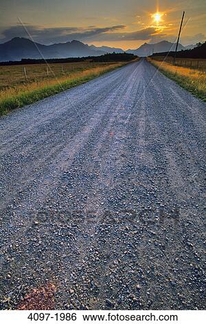 Stock Photograph - Road passing through a landscape with mountains in the background, Canadian Rockies, Waterton Lakes National Park, Alberta, Canada. Fotosearch