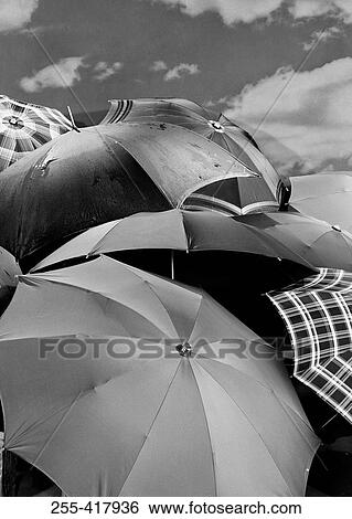 Several umbrellas stacked together with sky in background View Large Photo Image Stock Photograph - Several umbrellas stacked together with sky in background. Fotosearch