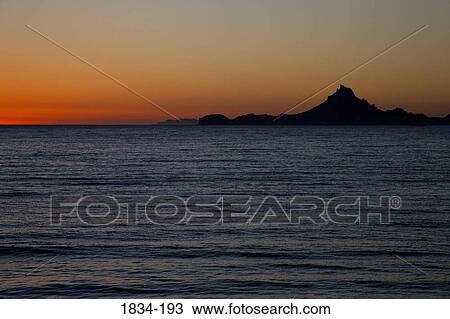Stock Image - Silhouette of a mountain peak at sunset, Sea of Cortez, Guaymas, Sonora, Mexico. Fotosearch