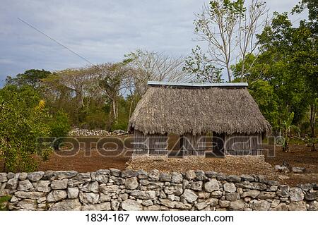 Stock Photo - Stone wall in front of a stick house, Izamal, Yucatan, Mexico. Fotosearch