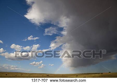 Storm clouds and rainbow over a landscape, New Mexico, USA View Large Photo Image Stock Photo - Storm clouds and rainbow over a landscape, New Mexico, USA. Fotosearch