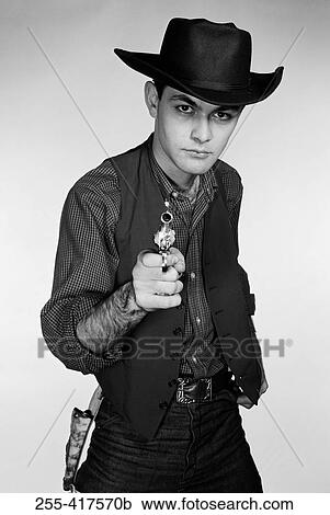 Studio portrait of cowboy aiming gun at camera View Large Photo Image Stock Image - Studio portrait of cowboy aiming gun at camera. Fotosearch
