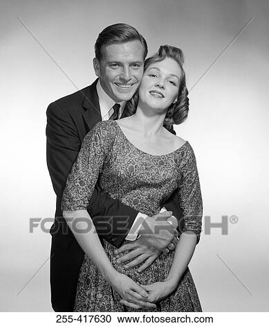 Stock Image - Studio portrait of happy couple embracing. Fotosearch