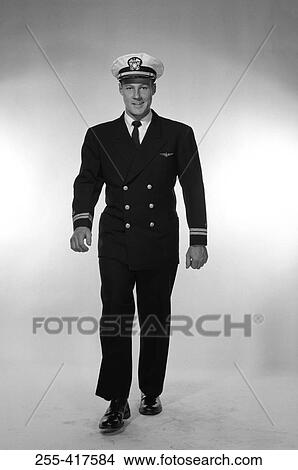Picture - Studio portrait of male pilot walking. Fotosearch