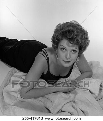 Studio portrait of young woman lying on front View Large Photo Image Stock Image - Studio portrait of young woman lying on front. Fotosearch