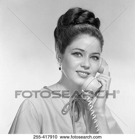 Studio portrait of young woman using telephone View Large Photo Image Stock Image - Studio portrait of young woman using telephone. Fotosearch