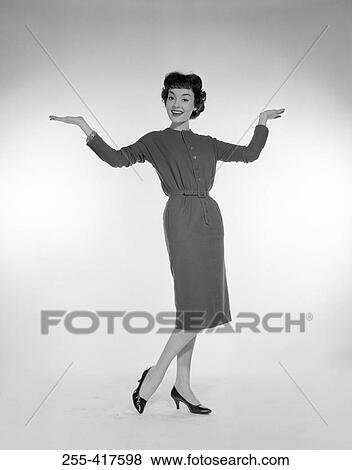 Stock Photo - Studio portrait of young woman with arms up. Fotosearch