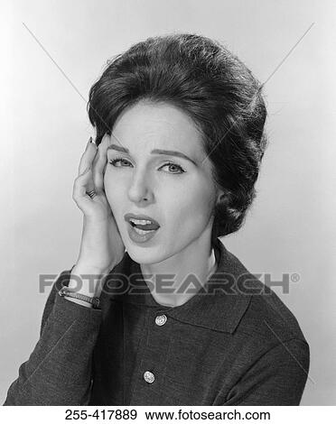 Stock Photo - Studio portrait of young woman with headache. Fotosearch