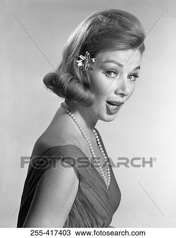 Stock Image - Surprised elegant woman looking at camera, studio shot. Fotosearch