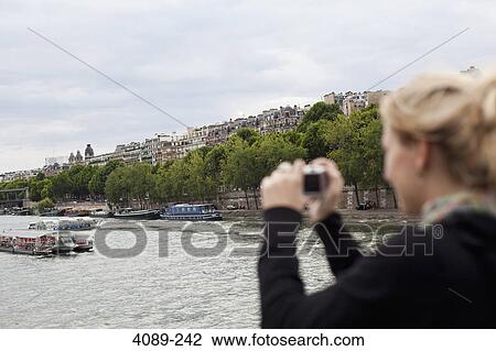 Teenage girl taking a picture of a river, Seine River, Paris, Ile-De-France, France View Large Photo Image Stock Image - Teenage girl taking a picture of a river, Seine River, Paris, Ile-De-France, France. Fotosearch