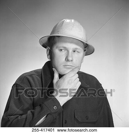 Stock Image - Thoughtful young man looking away, studio shot. Fotosearch