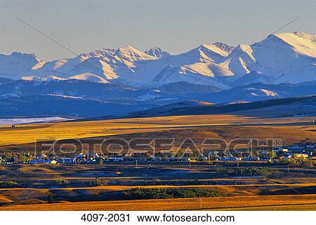 Stock Image - Town with mountains in the background, Town of Lumbrick, Rocky Mountains, Alberta, Canada. Fotosearch