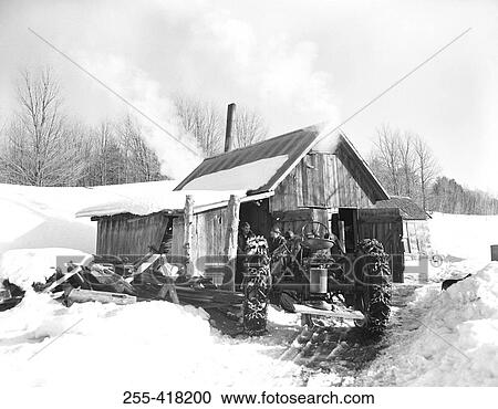 Stock Image - Tractor next to shed in winter. Fotosearch