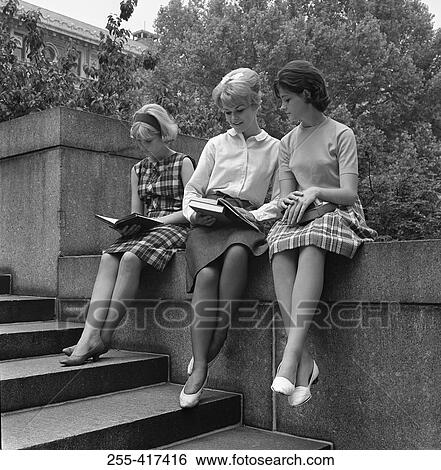 Tree young students sitting on wall and reading books View Large Photo Image Stock Photograph - Tree young students sitting on wall and reading books. Fotosearch