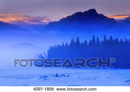 Stock Photography - Trees in front of mountains, Athabasca River, Mount Fryatt, Jasper National Park, Alberta, Canada. Fotosearch