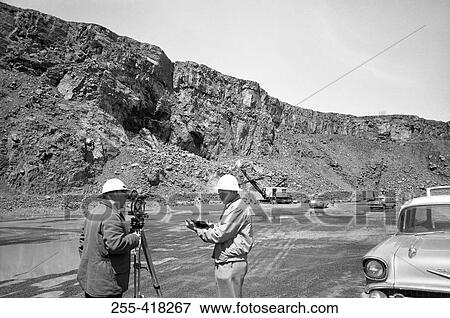 Stock Photo - Two engineers with theodolite. Fotosearch