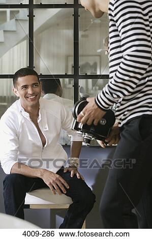 Two male friends smiling with a video camera, Manhattan, New York City, New York State, USA View Large Photo Image Stock Photograph - Two male friends smiling with a video camera, Manhattan, New York City, New York State, USA. Fotosearch